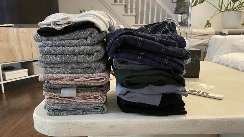 Neat stacks of folded towels and clothes on a table after laundry day