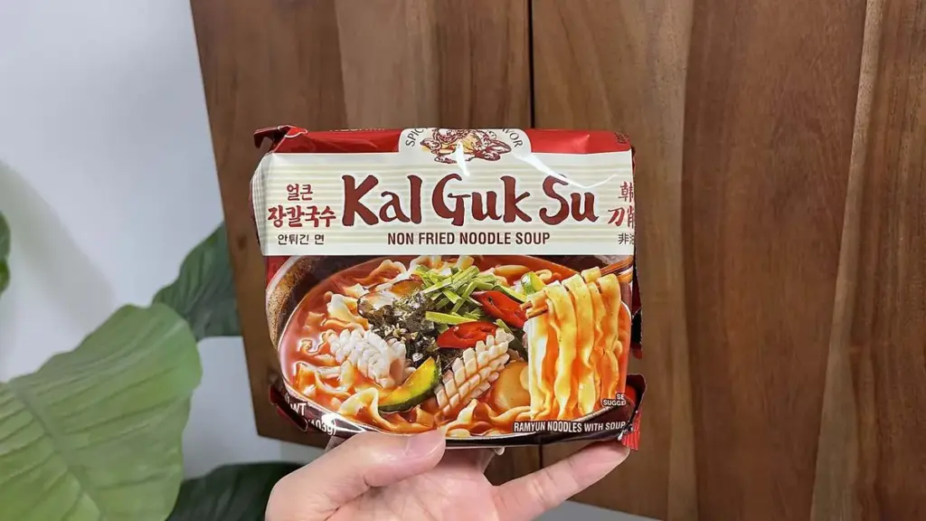 Hand holding a package of Nongshim jang kalguksu Korean instant noodles